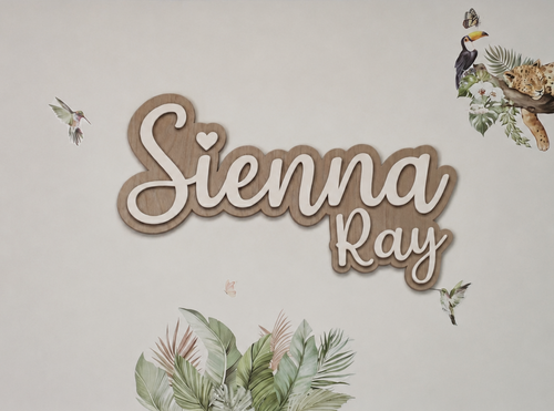 Decorative wall art with 'Sienna Ray' text and nature-themed elements on a light background
